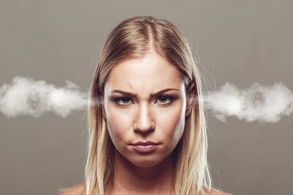 A blonde woman facing camera with smoke coming out of her ears.jpg