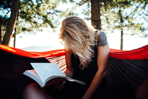 A_woman_reads_a_book_on_outdoors