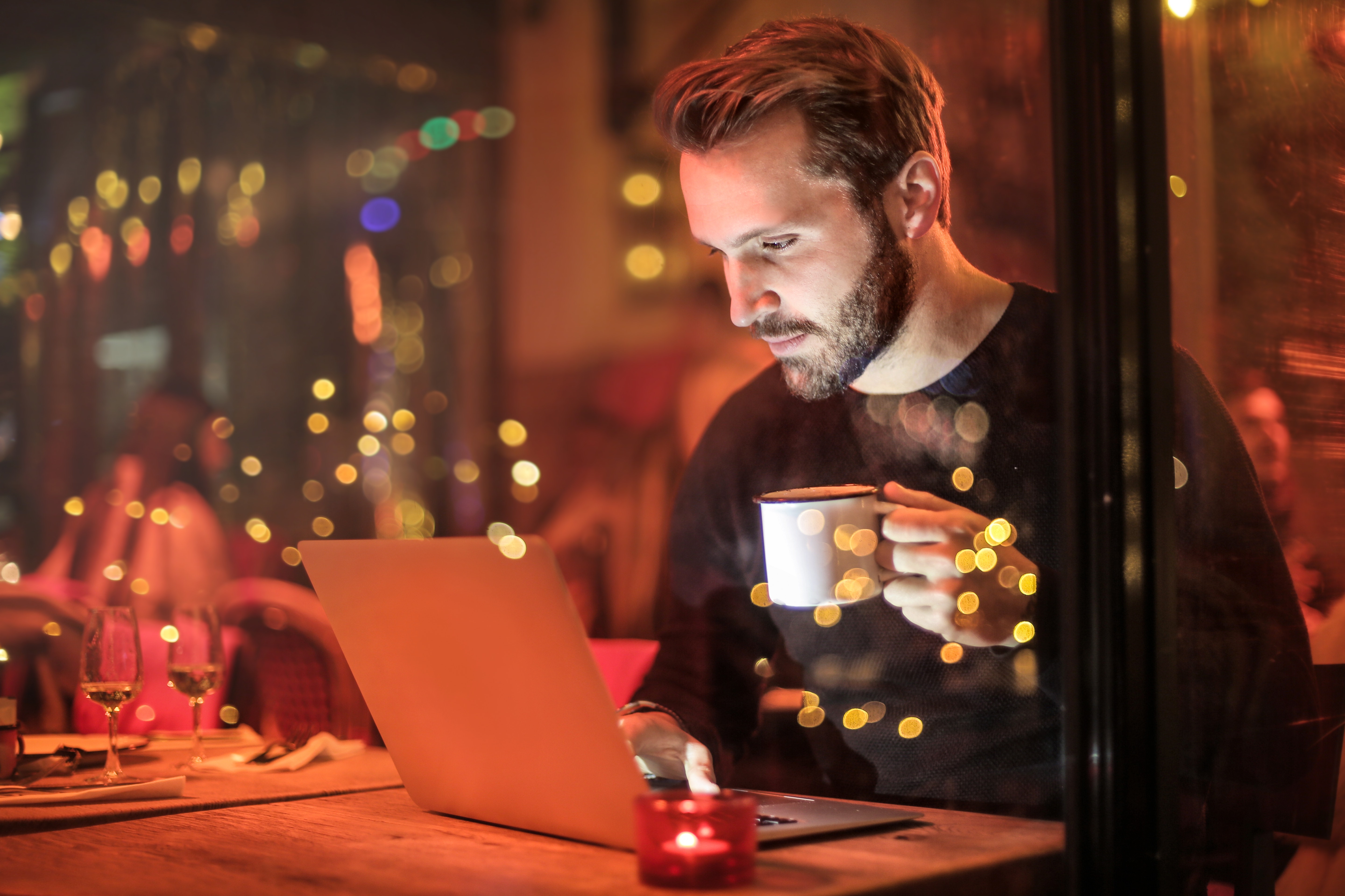 man-holding-mug-in-front-of-laptop-842548