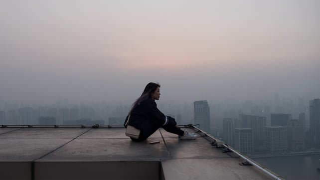 person sitting on rooftop with skyline in view.jpg