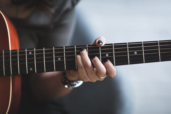 person with painted black nails plays guitar.jpg