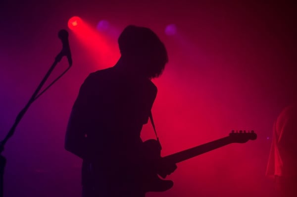 silhouette_of_a_musician_playing_guitar_in_red_lighting.jpg